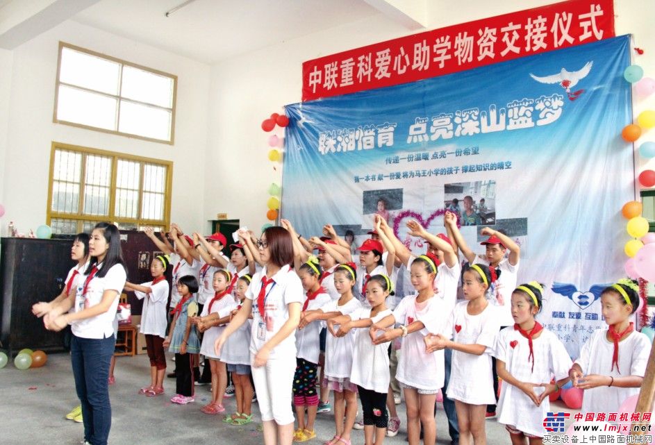 9月8日-10日,中联重科青年志愿者协会携手湖南教育频道,组成近30人的志愿团队,携带包括60套桌椅、38包书籍及衣物、1套广播系统、1套投影系统及7000元助学金等在内的共逾80000元的捐助物资,驱车奔往湘西吉首自治州保靖县马王乡马王小学,为马王小学援建了“联湘”爱心图书室。并以9月10日教师节为契机,联合湘西边城爱心网,举办了以“联湘惜育 点亮深山蓝梦”为主题的物资交接、图书室揭幕和节目演出活动。图为志愿者们与学生们一起表演“最好的未来”手语舞蹈。