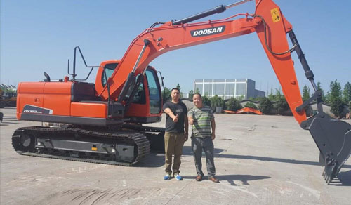 四川何老板(右)与心爱的斗山挖掘机